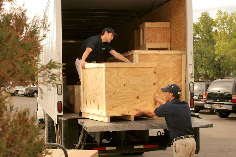 Navis Pack & Ship team loading crates into a truck for shipping in USA